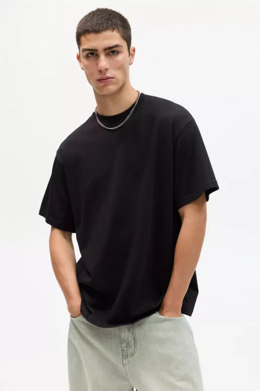Man wearing a black boxy oversized T-shirt in relaxed casual style